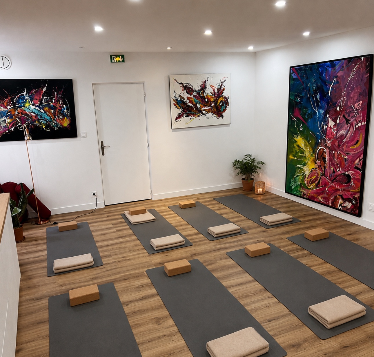 La salle de yoga Ma Maison du Bien-Être, avec tapis, accessoires et œuvres colorées
